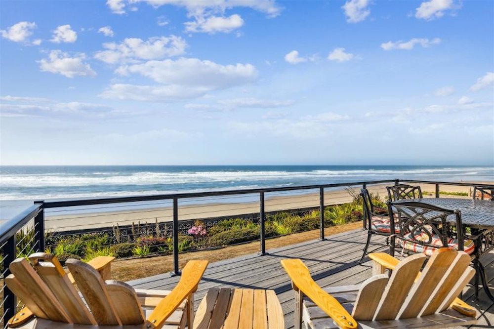 two empty chairs facing the Pacific on a balcony of a Cannon Beach, Oregon vacation rental