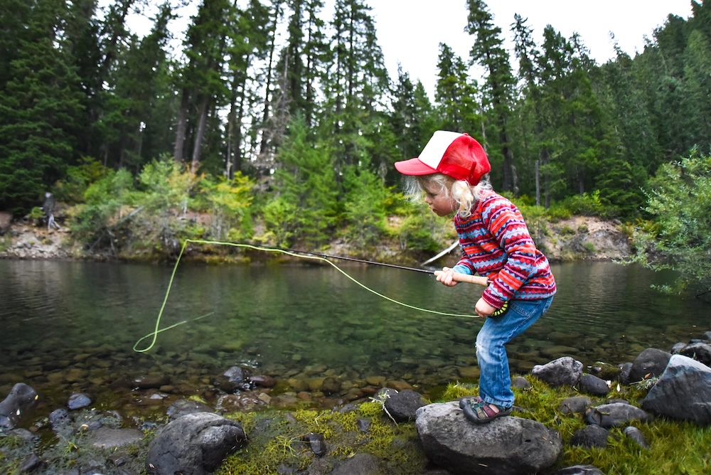 Boy fly fishing in a stream